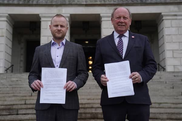 Loyalist activist Jamie Bryson and TUV leader Jim Allister on the steps of Stormont in Belfast with legal advice they commissioned from John Larkin KC on the DUP's deal with the government to return to Stormont