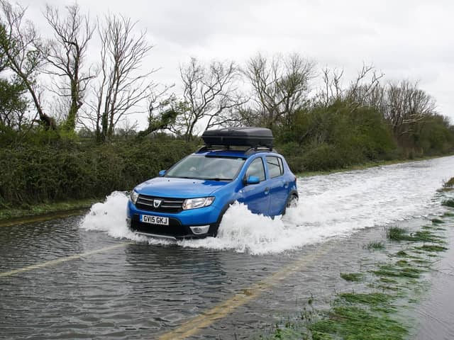 A car drives through flood water in Littlehampton, West Sussex, after the River Arun burst its banks overnight. Photo: Gareth Fuller/PA Wire