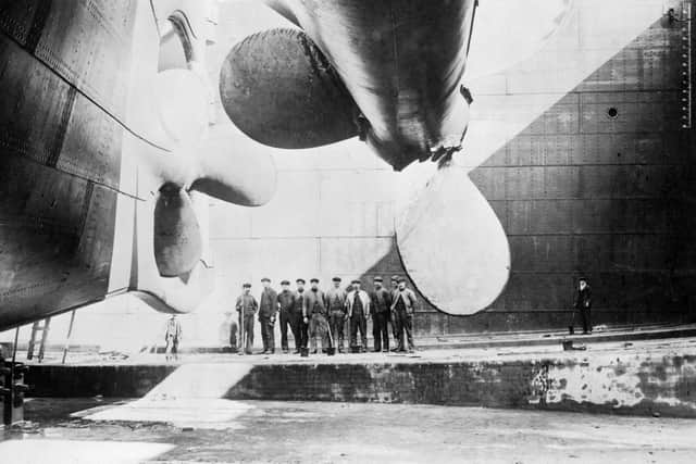 Workers pose near the port and centre propellers of the sister ship of the Titanic, RMS Olympic, in the Thompson Graving Dock during fitting out at the Harland and Wolff shipyard in Belfast, Northern Ireland, April 1911. (Photo by Robert Welch/Historica Graphica Collection/Heritage Images/Getty Images)