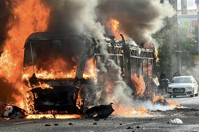 A Glider bus, set on fire by protesters, on the Newtownards Road in east Belfast, as disorder flared during an anti-immigration demonstration