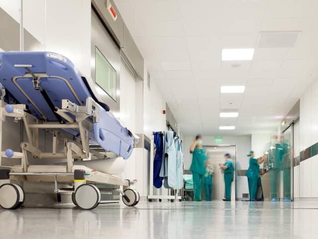 ADOBE STOCKBlurred figures of people with medical uniforms in hospital corridor