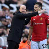 Dutch manager Erik ten Hag (L) speaks with Manchester United's Portuguese defender Diogo Dalot (R) during the match between Newcastle United and Manchester United at St James' Park.