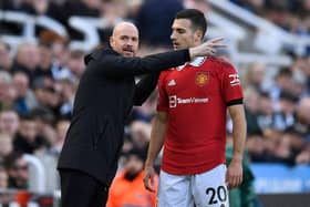 Dutch manager Erik ten Hag (L) speaks with Manchester United's Portuguese defender Diogo Dalot (R) during the match between Newcastle United and Manchester United at St James' Park.