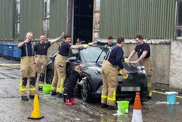 Firemen washing a car