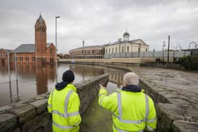 DFI workers look at the flooded water in a car park beside Riverside Reformed Presbyterian Church (left) and Newry Courthouse (right) in Newry Town, Co Down. Flooding was reported in parts of Northern Ireland, with police cautioning people against travelling due to an amber rain warning. The Met Office warning for Northern Ireland is the second highest level and covers Counties Antrim, Down and Armagh. Picture: Liam McBurney/PA Wire
