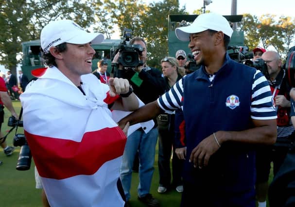 Northern Ireland golfer Rory McIlroy, clad in the Ulster Banner, talks to Tiger Woods after Europe defeated the USA in the 2012 Ryder Cup