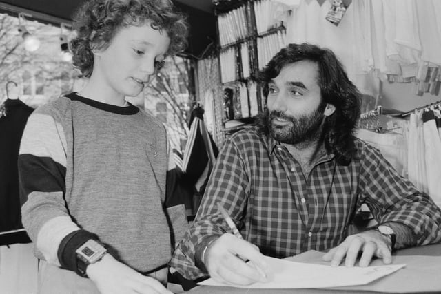 Northern Irish professional footballer George Best (1946 - 2005) signing autographs to a young fan, UK, 12th December 1984. (Photo by Mike Moore/Daily Express/Hulton Archive/Getty Images)
