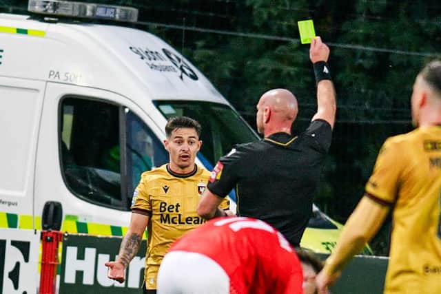 Jordan Stewart of Glentoran receives a yellow card. (Photo by Andrew McCarroll/Pacemaker Press)
