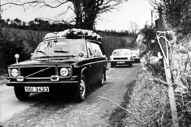 The hearse carrying Robert Freeburn, one of the victims of the Kingsmill Massacre passing the scene of the massacre, which is marked by a lone wreath on the right hand side of the road. Ten protestant workmen were shot dead by the Provissional IRA.