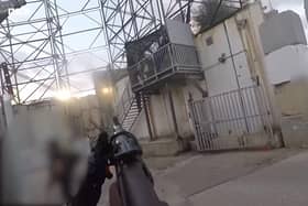 Image from a Hamas bodycam of a man storming an Israeli border post at the start of the October 7 killing spree