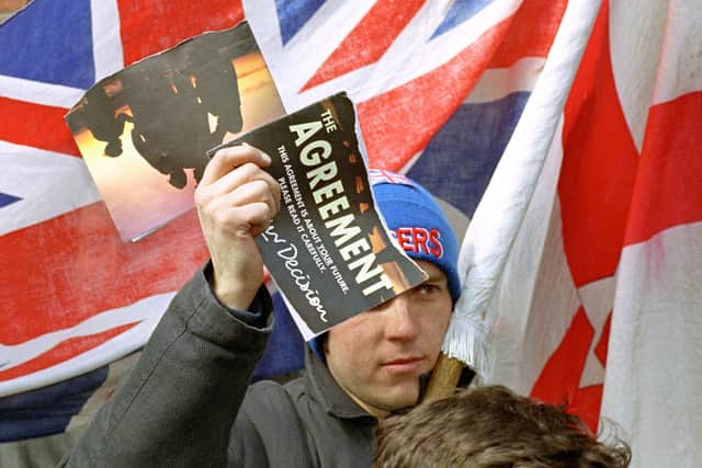 The 'Agreement' is torn in half by an unhappy demonstrator outside the Ulster Unionist Party HQ in Belfast in 1998. The middle ground which once was occupied by the UUP and SDLP has been largely destroyed. Photo Barry Batchelor/PA