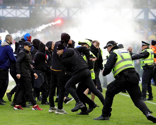 Police officer and stewards force fans back after they invaded the pitch following the Scottish Cup tie between Rangers and Celtic last month