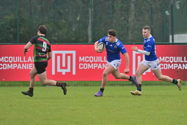 Queen's Lukas Kenny runs in to score a try against Highfield at The Dub in Belfast