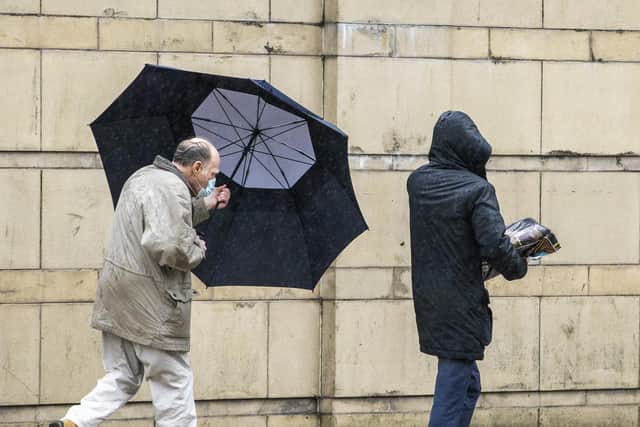 A man in Belfast struggles with his umbrella