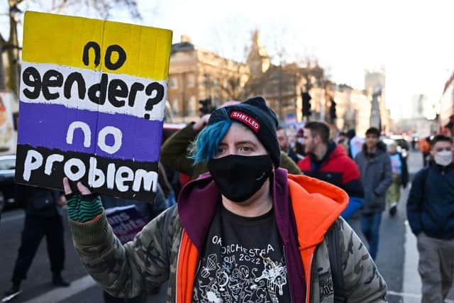 Demonstrators hold placards as they take part in a protest march for trans rights in central London, on January 21, 2022; the new QUB speech code has been extended to cover 'non-binary identities' – not just transgender ones