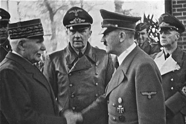 Adolf Hitler shakes hands with Philippe Petain, leader of the Vichy government