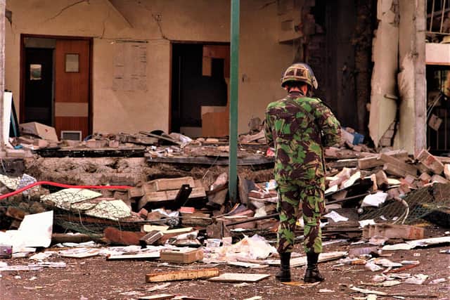 General image of a soldier in Belfast surveying bomb damage