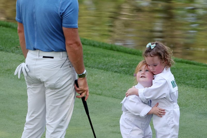 AUGUSTA, GEORGIA - APRIL 05: Rory McIlroy of Northern Ireland looks on as Ivy Lowry hugs Poppy McIlroy on the ninth green during the Par 3 contest prior to the 2023 Masters Tournament at Augusta National Golf Club on April 05, 2023 in Augusta, Georgia.