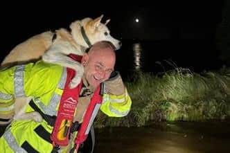 NIFRS Retained Crew Commander Dean McClatchy rescuing a dog from a flooded vehicle in Moira.