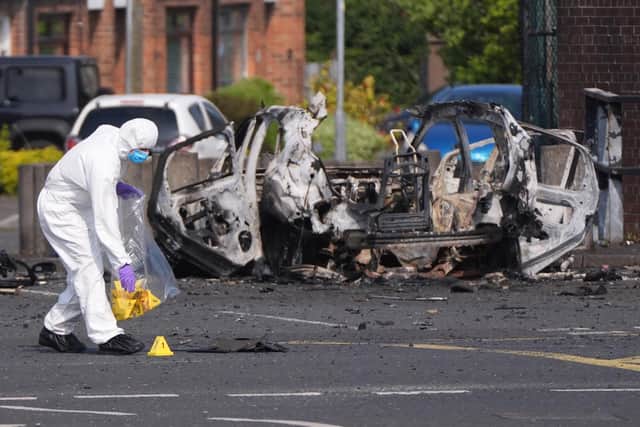 Forensic investigators in Dunmurry in Northern Ireland after a car explosion outside a police station, which saw homes in the area evacuated before the blast. Photo: Niall Carson/PA Wire