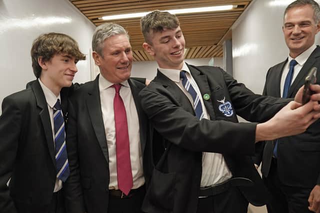 Labour leader Sir Keir Starmer poses for a selfie with students during a visit to St Columb's College in Derry, Northern Ireland. Picture date: Friday March 3, 2023.