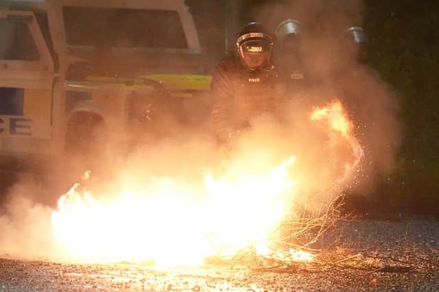 Police extinguish a fire in Portadown in Co Armagh, following three nights of disorder in Ballymena Photo: Brian Lawless/PA Wire