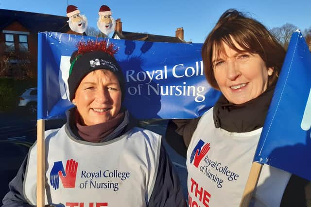 Nurses Claire Mackin, left, and Pamela McMullan, on strike at Lagan Valley Hospital on 20 December 2022. Both women say they are taking action to press for better working conditions for their two daughters, who are also nurses.