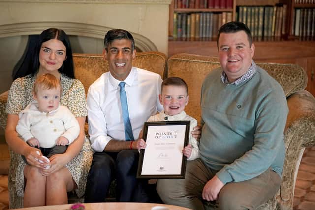 Six-year-old Daithi Mac Gabhann, who is awaiting a heart transplant, with his father Mairtin Mac Gabhann, mother Seph Ni Mheallain and younger brother Cairbre Mac Gabhann, as he is presented with an award recognising "outstanding volunteers" by Prime Minister Rishi Sunak, for his contribution to his community during the Points of Light Awards held at the Culloden Hotel in Belfast