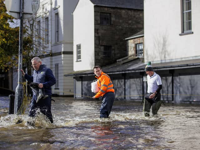 People walk through flood water on Bank Parade in Newry Town, Co Down. Flooding was reported in parts of Northern Ireland, with police cautioning people against travelling due to an amber rain warning. The Met Office warning for Northern Ireland is the second highest level and covers Counties Antrim, Down and Armagh. Picture date: Tuesday October 31, 2023. PA Photo. See PA story WEATHER Rain. Photo credit should read: Liam McBurney/PA Wire