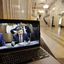 A laptop screen in the Great Hall at Parliament Buildings at Stormont shows a live feed of Minister for Health Robin Swann