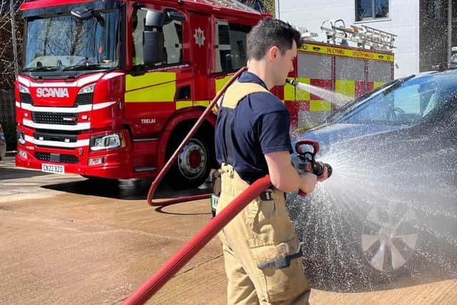 Fireman washing a car
