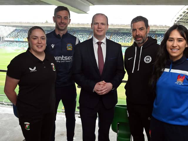 Communities minister Gordon Lyons (centre) at Windsor Park with representatives of local clubs