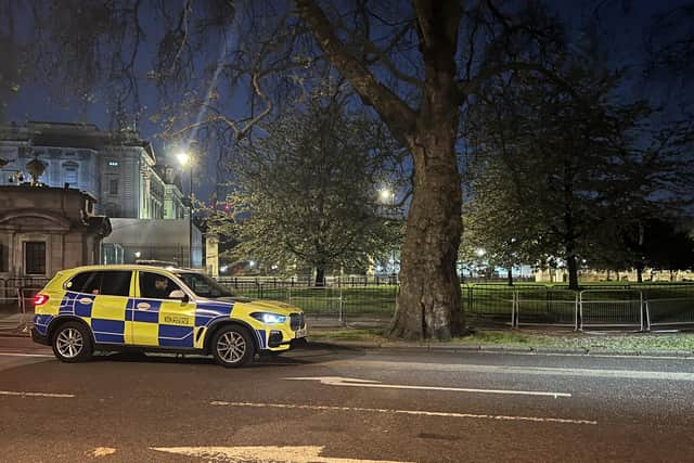 A police car outside Buckingham Palace, London, where a man has been arrested after throwing suspected shotgun cartridges into the palace grounds.