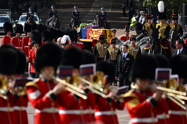 The coffin of Queen Elizabeth II, adorned with a Royal Standard and the Imperial State Crown is pulled by a Gun Carriage of The King's Troop Royal Horse Artillery, during a procession from Buckingham Palace to the Palace of Westminster, in London on September 14, 2022