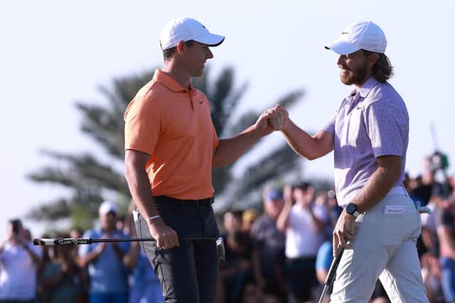 Northern Ireland's Rory McIlroy and Tommy Fleetwood bump fists on the 18th green after Fleetwood holed a putt to win the Dubai Invitational