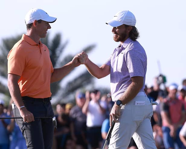Northern Ireland's Rory McIlroy and Tommy Fleetwood bump fists on the 18th green after Fleetwood holed a putt to win the Dubai Invitational