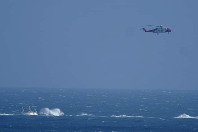 A helicopter from the Irish Coast Guard hovers above a stranded boat off the coast of Blackwater, Wexford. A major multi-agency operation is underway off the coast of Wexford after a boat ran aground on Monday.  Photo: Niall Carson/PA Wire
