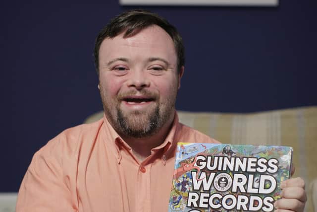 Actor James Martin at his family home in south Belfast holding a copy of Guinness of World Records 2024 in which he appears, James has been made an MBE (Member of the Order of the British Empire) for services to Drama in Northern Ireland.