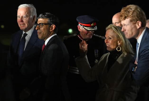 US President Joe Biden (L) reacts as he is greeted by Britain's Prime Minster Rishi Sunak (2L) after disembarking from Air Force One upon arrival at Belfast International Airport on April 11, 2023, starting a four day trip to Northern Ireland and Ireland to launch 25th anniversary commemorations of the "Good Friday Agreement" deal that brought peace to Northern Ireland. - US President Joe Biden arrived in Northern Ireland on Tuesday, hoping to help maintain the fragile peace brokered 25 years ago after decades of sectarian violence over British rule. (Photo by Jim WATSON / AFP) (Photo by JIM WATSON/AFP via Getty Images)