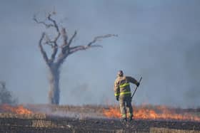A firefighter tackles a blaze in a Co Down field made famous by the music star Rihanna. Picture date: Wednesday August 31, 2022.
