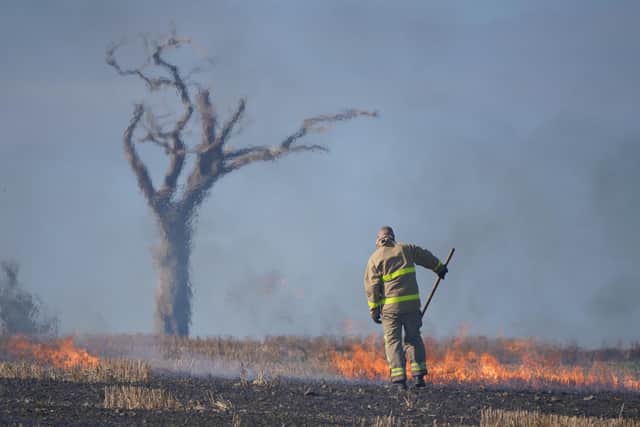 A firefighter tackles a blaze in a Co Down field made famous by the music star Rihanna. Picture date: Wednesday August 31, 2022.