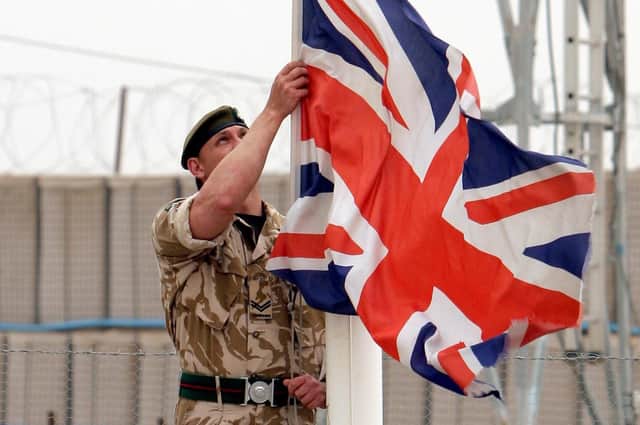 A British army corporal lowers the Union flag during a ceremony at a British military base in Basra, Iraq in 2007