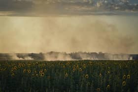 A smoke rises over sunflowers field on the frontline in Donetsk region, Ukraine on Wednesday. Christian Aid, has said that Russia's unilateral decision on grain had again put so many at risk from rising food prices and had exposed “the fragility of the world's food system” (AP Photo/Libkos)