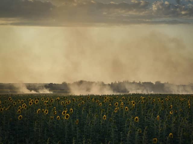A smoke rises over sunflowers field on the frontline in Donetsk region, Ukraine on Wednesday. Christian Aid, has said that Russia's unilateral decision on grain had again put so many at risk from rising food prices and had exposed “the fragility of the world's food system” (AP Photo/Libkos)