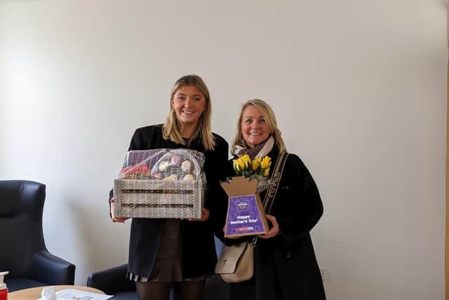 Kathy Loughridge is presented with her hamper and flowers by Claire Murphy from Henderson Group who thanked her for all her volunteering and fundraising efforts for Marie Curie.