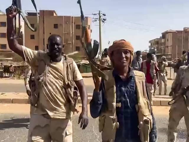 Sudanese paramilitary fighters wave assault rifles cross a street in the East Nile district of Khartoum. The brutality facing the people of Ukraine, and now Sudan, put our concerns in a certain perspective(Photo by -/Rapid Support Forces (RSF)/AFP via Getty Images)