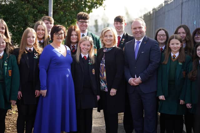Former US secretary of state and Chancellor of Queen's University Belfast, Hillary Clinton (centre), stands with pupils, Darren Mornin (right), principal of Limavady High School and Rita Moore (left), principal of St Mary's, during a visit to Limavady High School, Co Londonderry, to preside over an honorary graduation ceremony to mark the contribution of the schools' principals shared education model