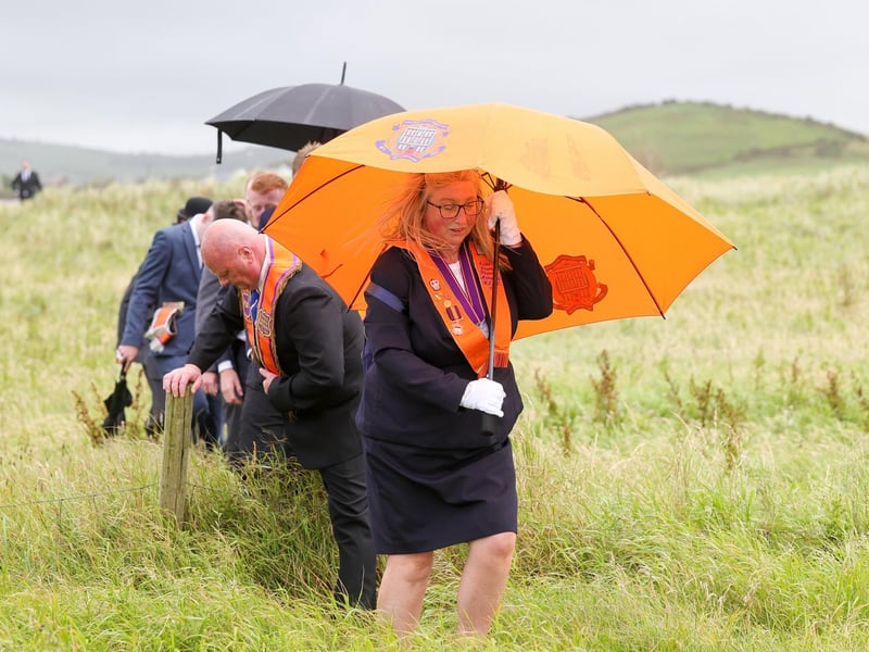 Orange men and women make their way through the dunes to the beach