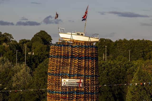 A boat flying the Union Jack flag placed on the top of the pyre with a banner that reads "No Irish Sea border" on the Moygashel Bonfire, Co Tyrone, ahead of it being lit on Saturday. Photo: Liam McBurney/PA Wire