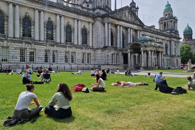 Thursday saw office and shop workers at last able to soak up some lunchtime rays in the grounds of Belfast City Hall, after the site was shut much of the week to dismantle a continental market. Photo: Iain Gray/News Letter
